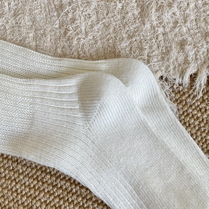 Close-up of white ribbed knit calf socks showing soft texture and high-quality weave