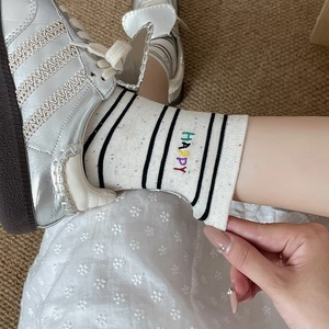 Japanese style white cotton socks with black stripes and colorful HAPPY embroidery details