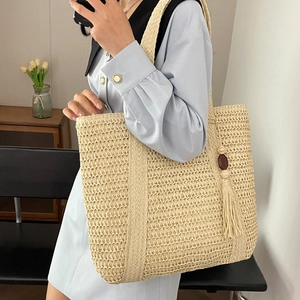 Large woven straw tote bag with decorative fringe and beads for women’s casual spring style