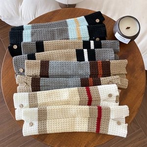 Close-up of knit leg warmers with retro wooden buttons and colorful striped patterns