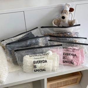 Detailed cable knit leg warmers with pom poms in various colors and clear packaging