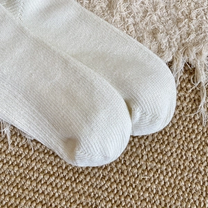 Close-up of white vertical ribbed knit socks showing high-quality cotton texture