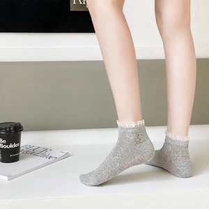 Détail de chaussettes grises avec bordure en dentelle blanche et texture côtelée
