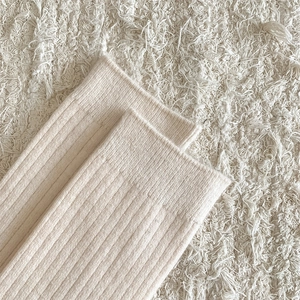 Close-up of thick beige ribbed knit wool socks showing high-quality texture and warm fabric