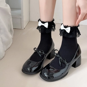 Klassische Mary Jane Schuhe aus schwarzem Lackleder mit weißen Spitzen-Schleifensocken