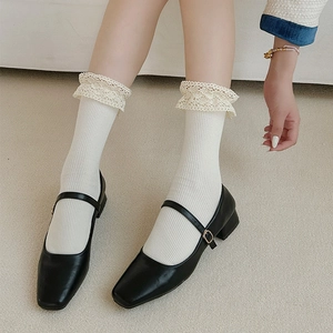 Detail of white lace ruffle socks paired with vintage black Mary Jane shoes for women