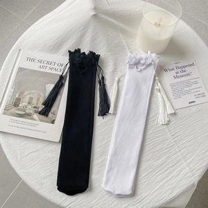 Detail of vintage knee-high socks with delicate lace edges and elegant side tassels