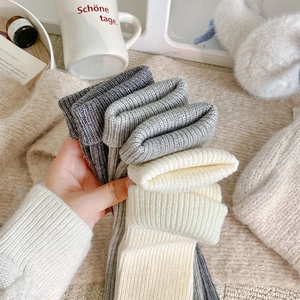 Close-up of thick ribbed knit leg warmers in grey and beige colors for winter