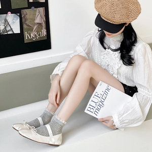 Chaussettes grises en tricot avec bordure en dentelle blanche et ballerines beiges