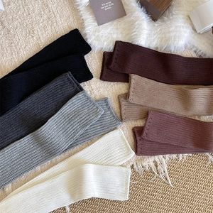 Close-up of ribbed knit leg warmers in various neutral colors for autumn winter style