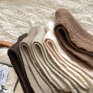 Detailed knit texture and ribbed cuffs of thick wool socks in earth tone colors