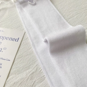Detail of white ribbed knit socks with soft texture and minimalist aesthetic design