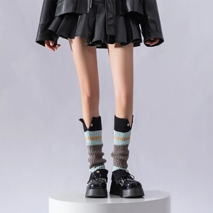 Detailed knit texture of colorful striped leg warmers with retro gold button accents