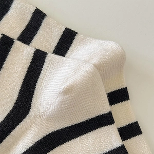 Close-up of black and white striped wool socks showing fine knit texture and heel stitching