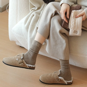 Detail of warm winter home set with suede slippers and wool socks featuring heart embroidery