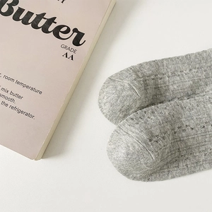Gros plan détaillé de chaussettes grises en dentelle montrant la texture et les mailles