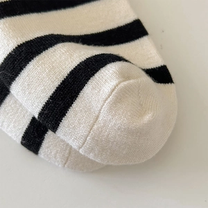 Close-up of seamless toe stitching and high-density knit of black striped wool socks