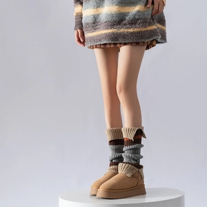 Detail of striped knit leg warmer with button accents on a camel suede platform boot