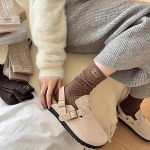 Detail view of wool-blend crew socks with heart embroidery and beige suede clogs