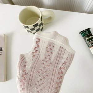 Détail de chaussettes en dentelle à damier rouge montrant la maille respirante