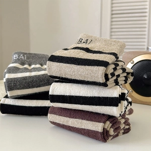 Close-up of thick striped wool socks in four colors with BAI embroidery for winter