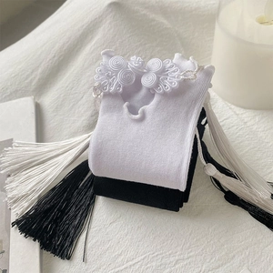 Detailed shot of Chinese style socks featuring elegant frog buttons and long silk tassels
