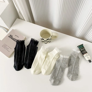Détails de dentelle et motifs à carreaux ajourés sur des chaussettes en coton