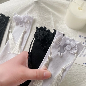 Detail of Chinese style mid-calf socks with delicate knot buttons and silk tassels