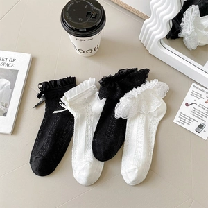 Detailed view of lace ruffled cuffs and satin bows on mesh Lolita style socks