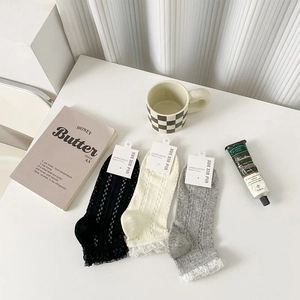Détail de chaussettes côtelées pour femmes avec dentelle blanche en trois couleurs neutres