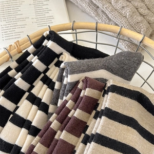 Close-up of assorted striped and checkered wool socks folded neatly in a basket