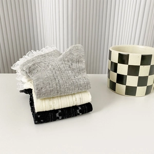 Détail du bord en dentelle et du motif en maille sur chaussettes en coton mélangé