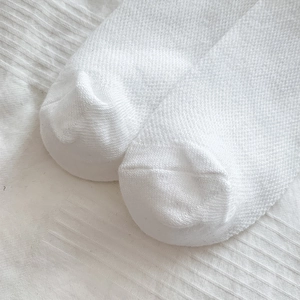 Nahaufnahme weißer Spitzensocken mit atmungsaktivem Mesh und glatten Zehennähten