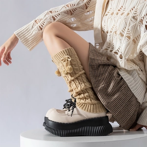 Lolita knit leg warmers with pom poms and cable patterns paired with platform shoes
