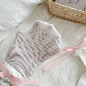 Detail von weißen Netzsocken mit Spitzenborte und rosa Schleifen im Lolita-Stil