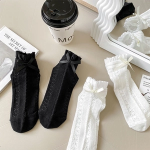 Lace Lolita mesh socks featuring ruffled cuffs and silk bows in a refined lifestyle setting