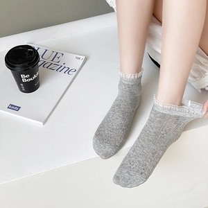Gros plan de chaussettes grises avec bordure en dentelle blanche et maille respirante