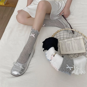 Detail of ruffled cuff socks with bows and mesh knit texture in a cozy setting