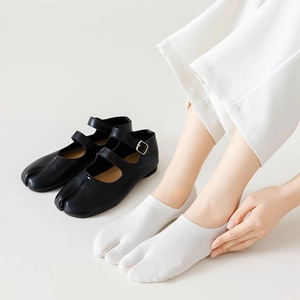 Gros plan de chaussettes tabi blanches avec des chaussures Mary Jane noires