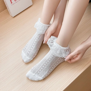 Close-up of white Lolita lace socks with hollow jacquard patterns and ruffled edges