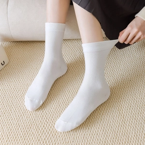 Detail showing high elasticity and ribbed cuff of white cotton mid-calf socks