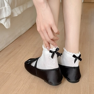 Lolita style white ankle socks with lace trim and black bows paired with Mary Jane shoes