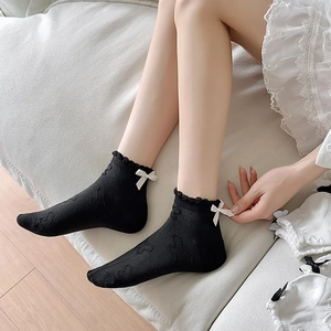 Black JK style lace socks with white silk bow and floral pattern texture on feet