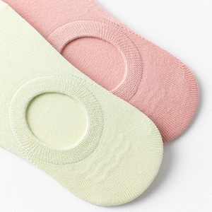 Détail du tricot des chaussettes invisibles décolletées en vert clair et rose
