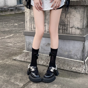 Gros plan de chaussures Mary Jane Lolita avec chaînes perles et chaussettes à nœud