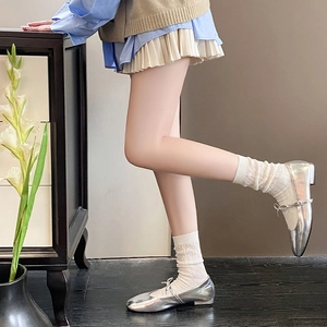 Detail of silver metallic Mary Jane shoes with delicate bow and white lace socks