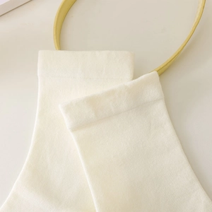Macro detail of ribbed knit texture on cream-colored mid-calf cotton socks