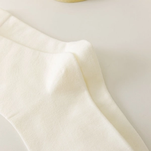 Close-up of white knitted socks showing high-density texture and soft ribbed cotton fabric