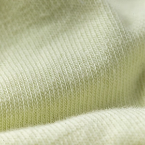Gros plan macro sur la texture du tricot vert clair doux avec des détails fins