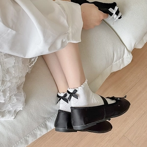 Detail of white ruffle trim lolita socks with black bow and heart jacquard pattern